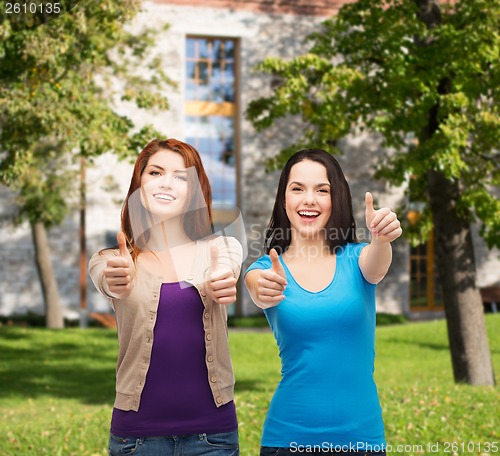 Image of two smiling girls showing thumbs up