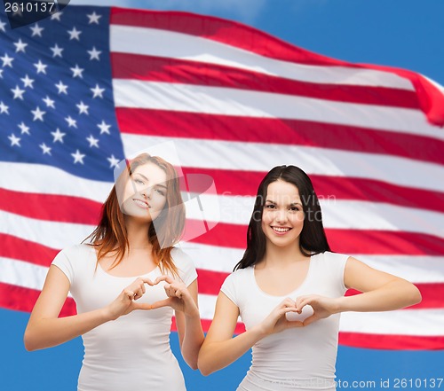 Image of two smiling girls showing heart with hands