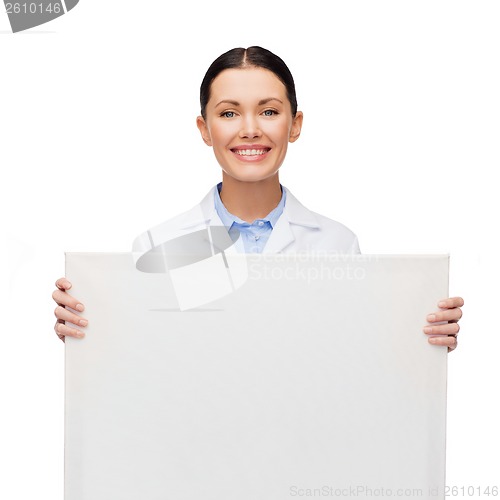 Image of smiling female doctor with white blank board