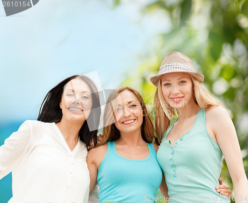 Image of group of smiling girls chilling on the beach