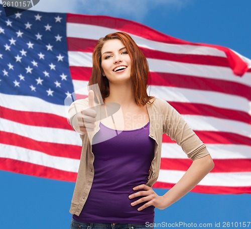 Image of smiling girl in casual clothes showing thumbs up