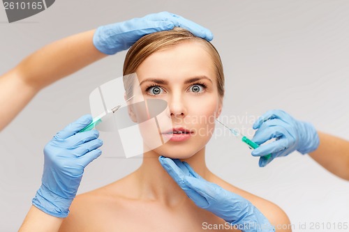 Image of woman face and beautician hands with syringe