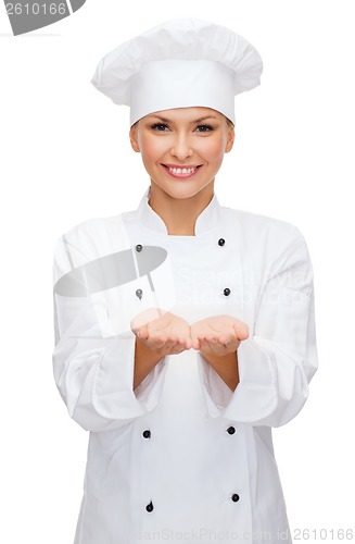Image of smiling female chef holding something on hands