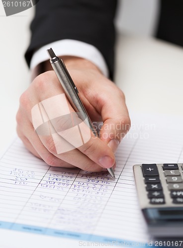 Image of close up of businessman with papers and calculator