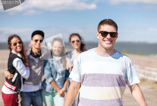 Image of teenage boy with sunglasses and friends outside
