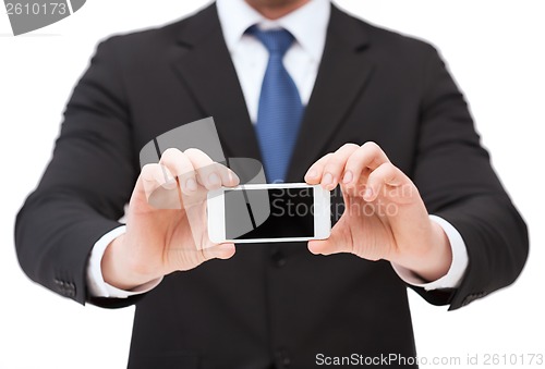 Image of businessman showing smartphone with blank screen