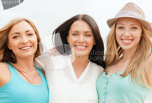 Image of group of smiling girls chilling on the beach