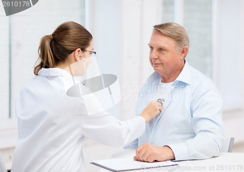 Image of female doctor with old man listening to heart beat