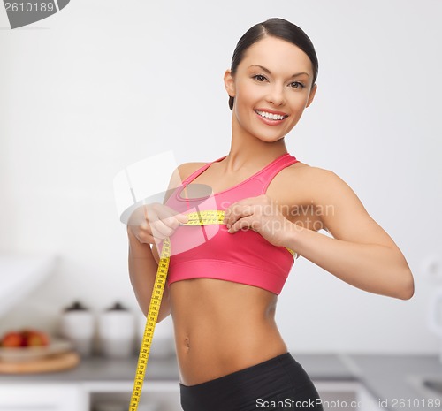 Image of sporty woman measuring her breast