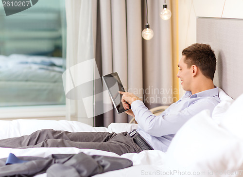Image of happy businesswoman with tablet pc in hotel room