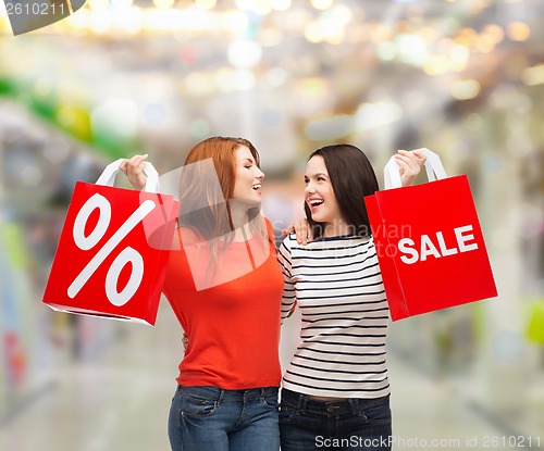 Image of two smiling teenage girl with shopping bags