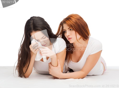 Image of one teenage girl comforting another after break up