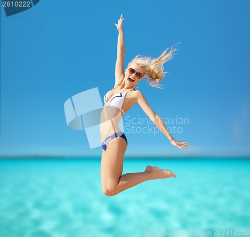 Image of woman jumping on the beach