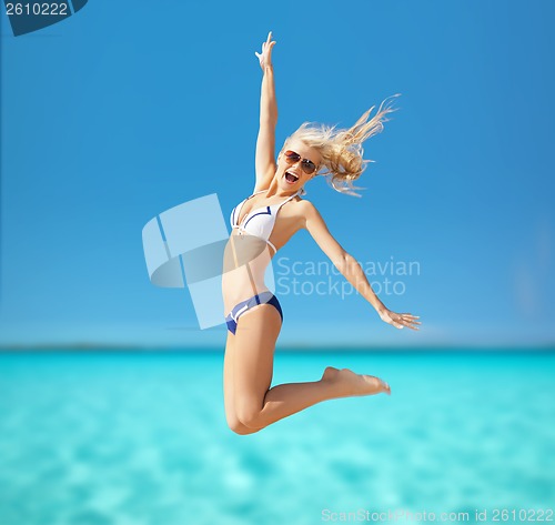 Image of woman jumping on the beach