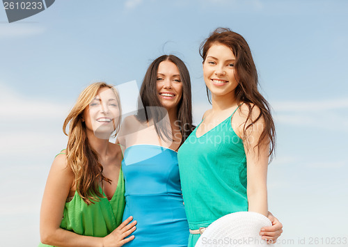 Image of smiling girls walking on the beach