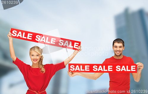 Image of woman and man with red sale signs