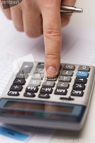 Image of close up of businessman with papers and calculator