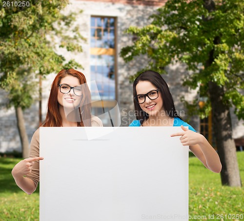 Image of two smiling girls with eyeglasses and blank board