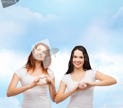 Image of two smiling girls showing heart with hands