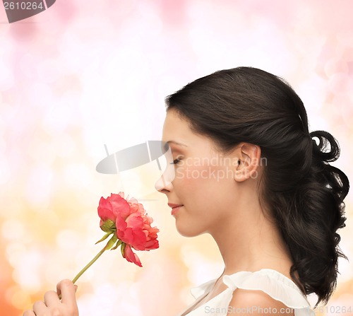 Image of smiling woman smelling flower