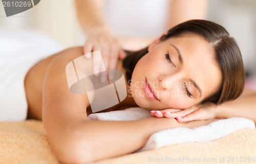 Image of beautiful woman in spa salon getting massage