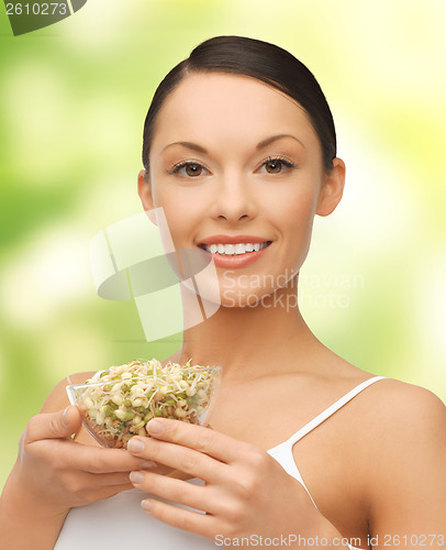 Image of healthy woman holding bowl with sprout
