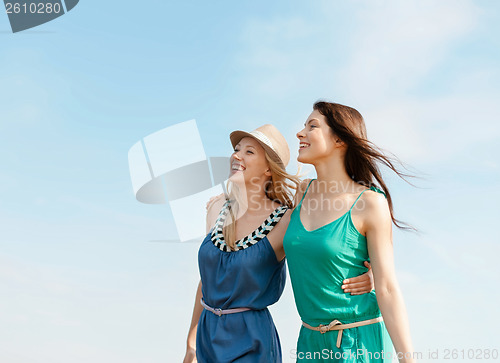 Image of smiling girls walking on the beach