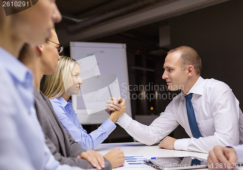 Image of businesswoman and businessman arm wrestling