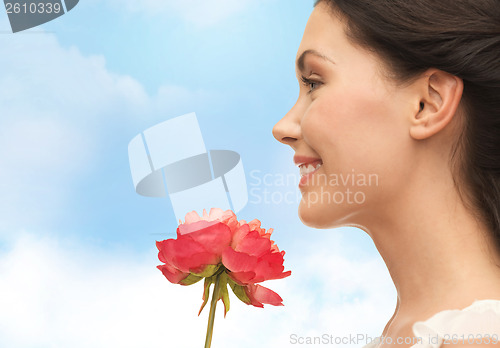 Image of smiling woman smelling flower