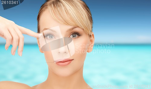 Image of beautiful woman touching her eye area