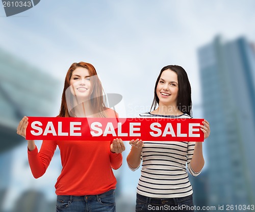 Image of two smiling teenage girl with percent sign on box