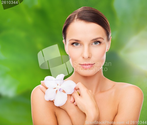 Image of relaxed woman with orchid flower