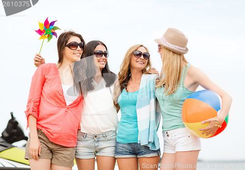 Image of smiling girls in shades having fun on the beach