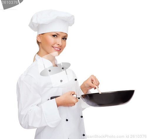 Image of smiling female chef with pan and spoon