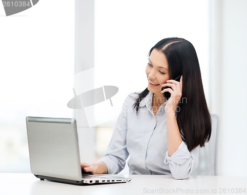 Image of businesswoman with laptop and cell phone