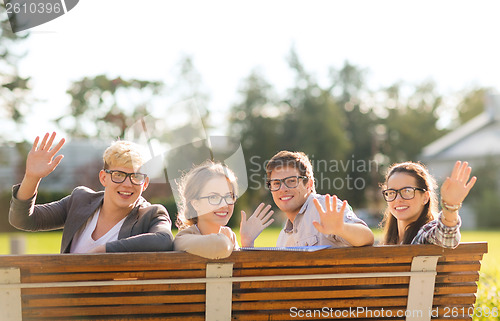 Image of group of students or teenagers waving hands