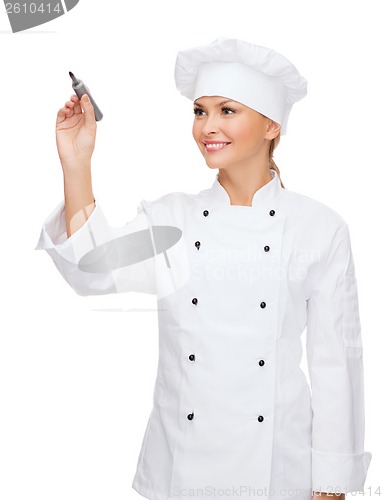 Image of smiling female chef writing something on air