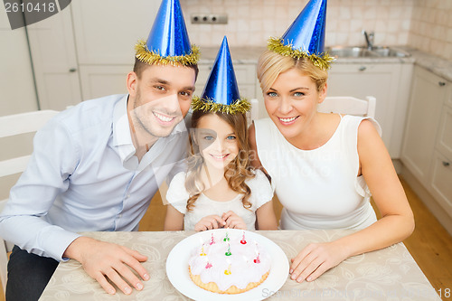 Image of smiling family in blue hats with cake