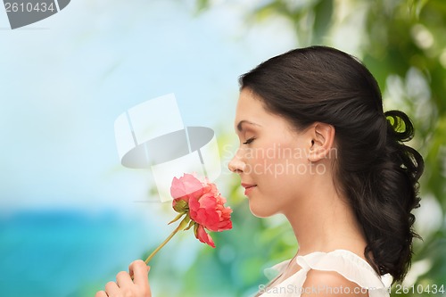 Image of smiling woman smelling flower