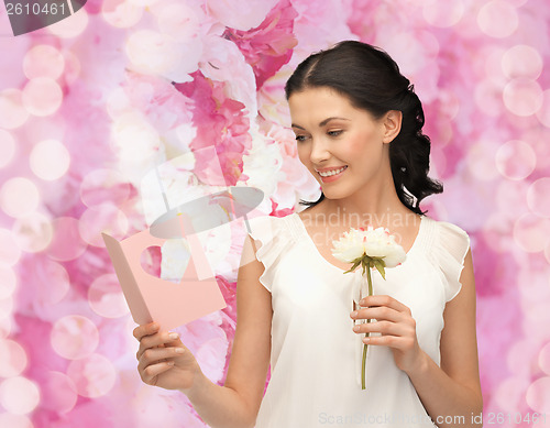 Image of young woman holding flower and postcard