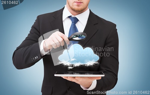 Image of businessman hand holding magnifier over tablet pc