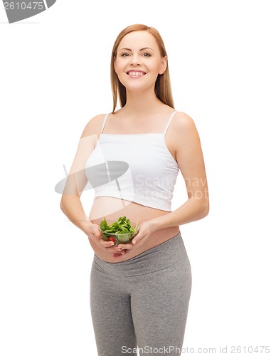 Image of happy future mother with bowl of salad