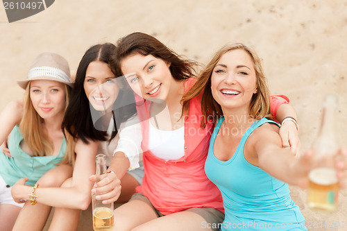 Image of smiling girls with drinks on the beach