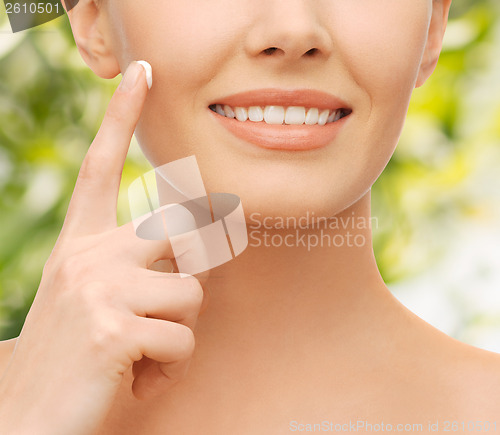 Image of beautiful woman applying moisturizing cream