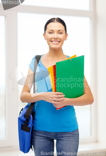 Image of female student with folders and bag at school