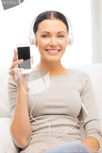 Image of woman with smartphone and headphones at home