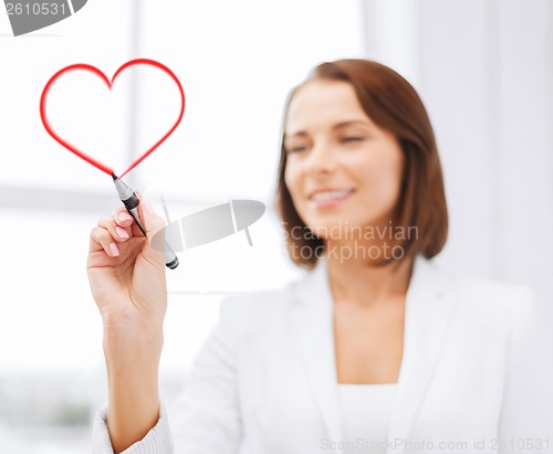 Image of businesswoman drawing heart in the air