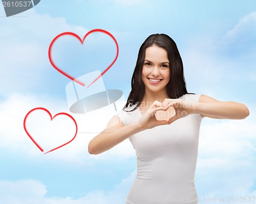 Image of smiling girl showing heart with hands