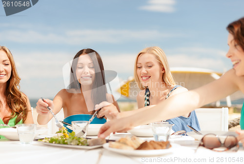 Image of smiling girls in cafe on the beach