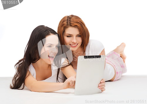 Image of two smiling teenage girls with tablet pc computer